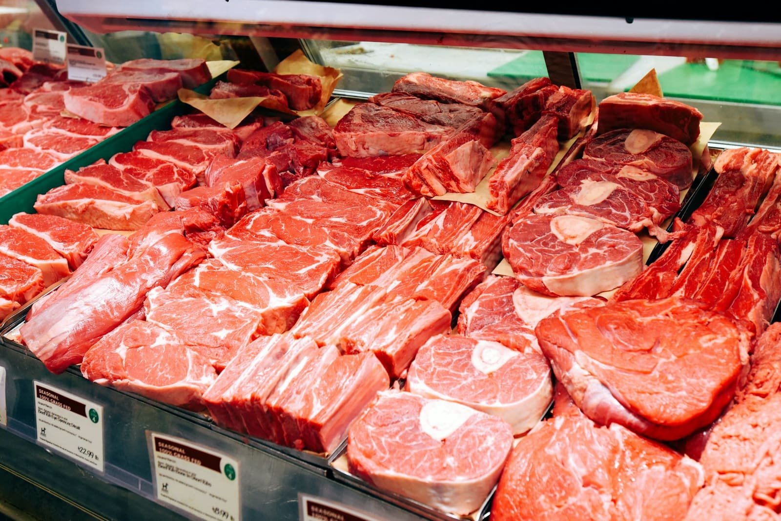 Fresh cuts of meat laid out across a butcher's counter display